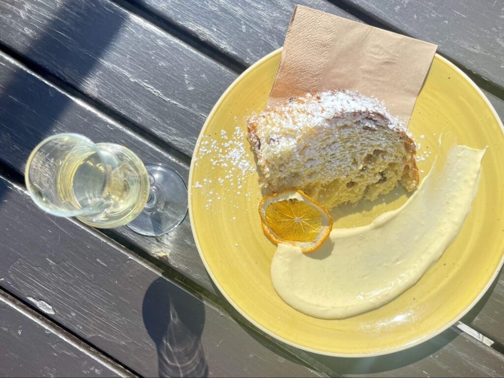 Eating a slice of panettone paired with white wine