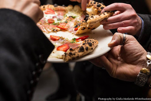hands grabbing pizza slices